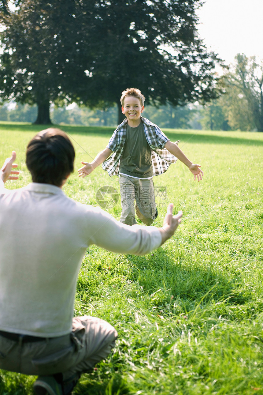 儿子在公园里向他爸爸跑去图片