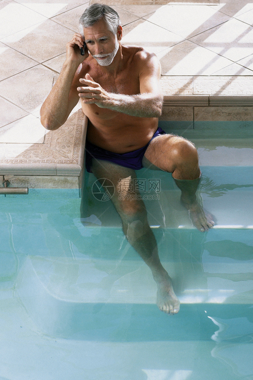 游泳池里打电话的男人图片