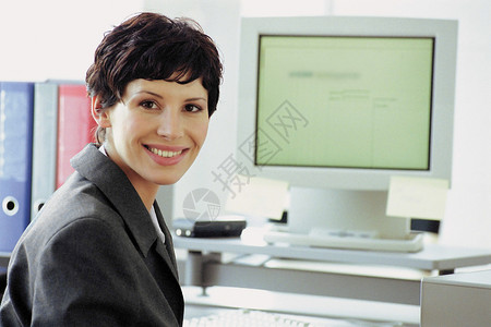 电脑旁的女性商务人士图片
