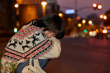 中国街角青年女性路边忧伤的抱膝哭泣背景