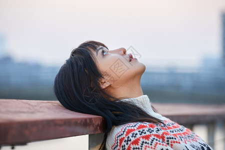 头发花纹青年女性背靠栏杆背景