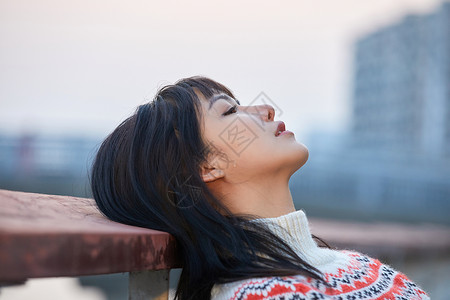 头发花纹青年女性背靠栏杆背景