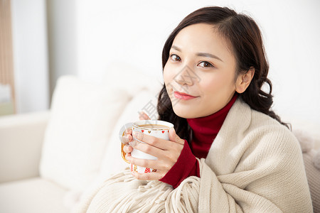 女性冬季居家端着咖啡背景图片