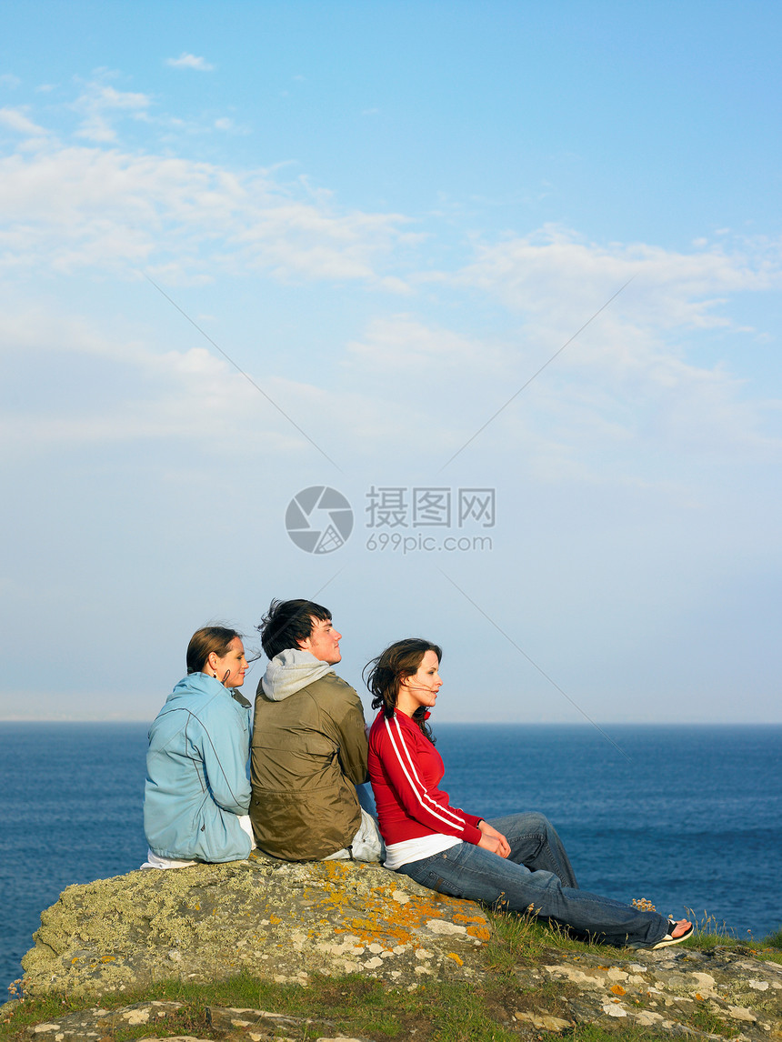 坐在石头上的三个年轻人图片