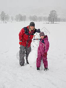 父亲和女儿堆雪人图片