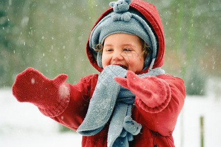 一个围巾在雪地里蹒跚学步的孩子背景