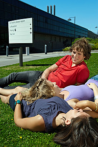 三个学生在草地上休息阳光高清图片素材