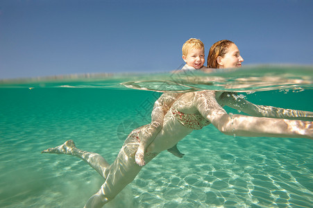 在水里背着孩子的妈妈开心高清图片素材