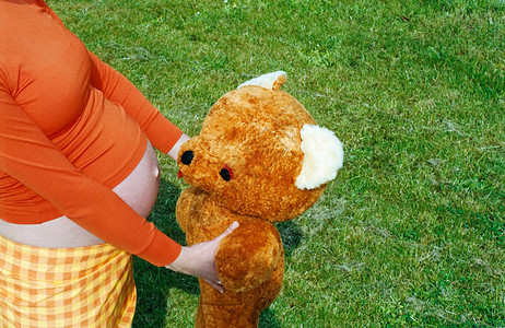 抱着泰迪熊的孕妇高清图片