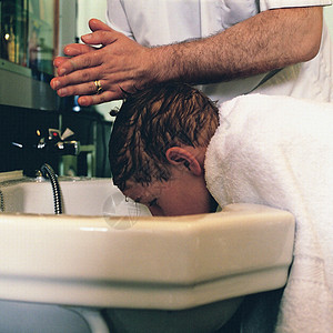 给男孩洗头发的理发师图片