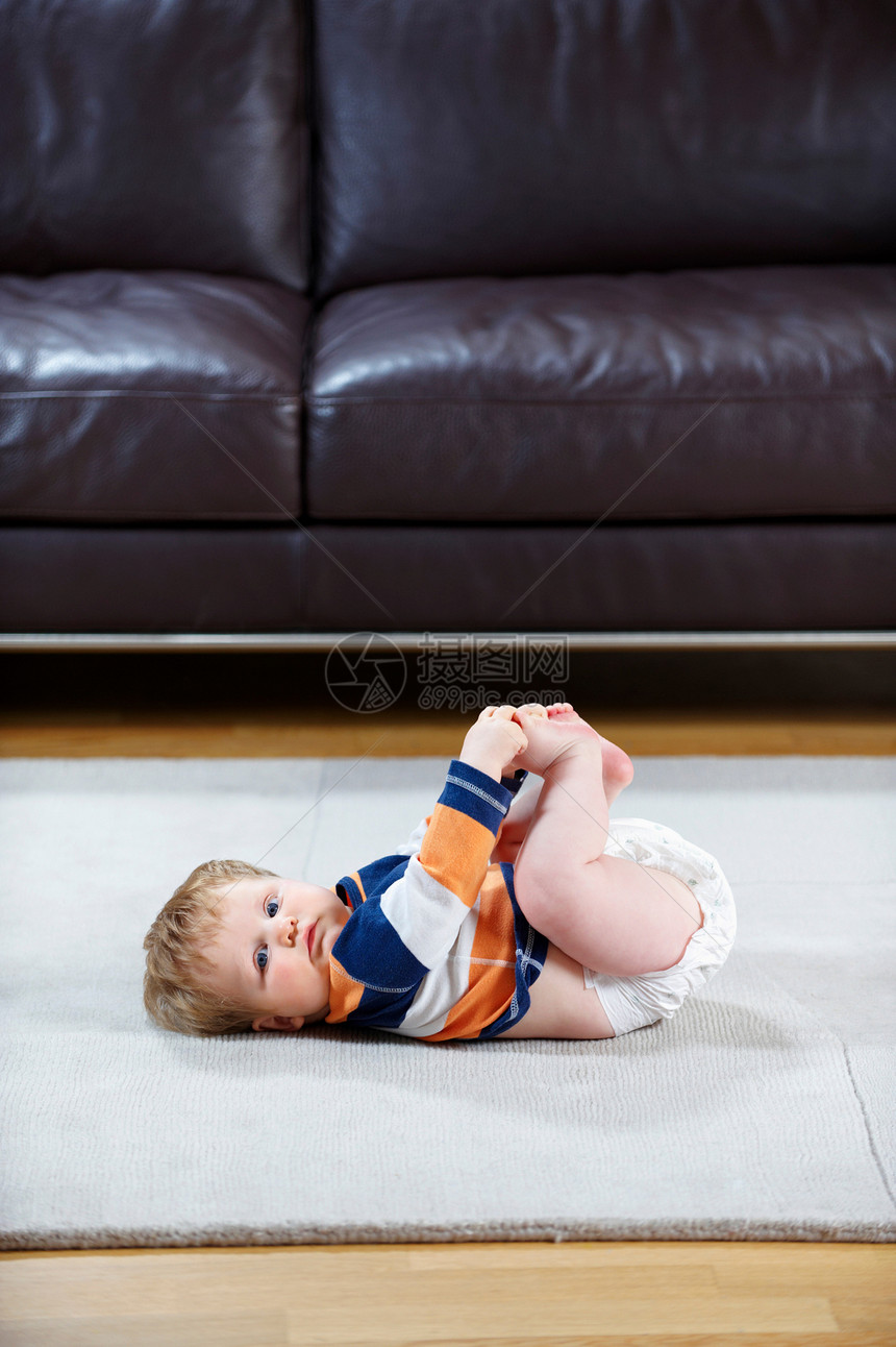 8个月大的婴儿穿着尿布躺在地毯上图片