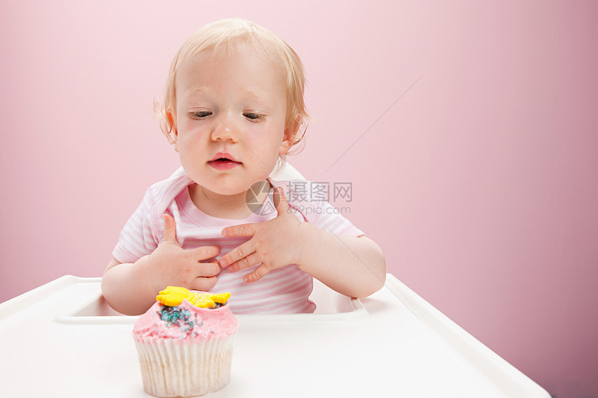 看着纸杯蛋糕的小女孩图片