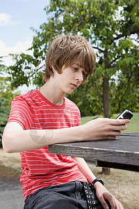 十几岁的男孩看着手机图片