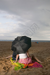 海滩上打伞的情侣图片