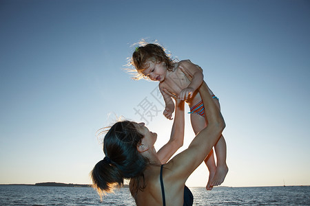 母亲和女儿在海边女孩高清图片素材