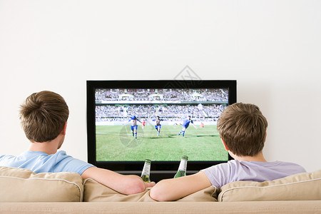 看足球比赛两个年轻人在电视上看足球背景