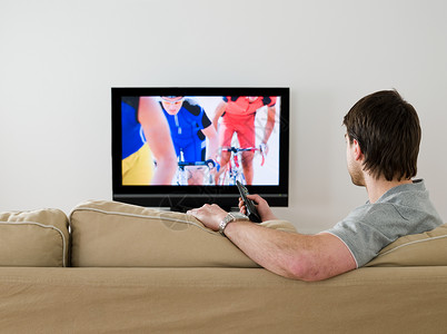 男人看电视一个在电视上看自行车比赛的人背景