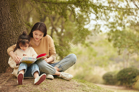 温馨母女坐在树下读书亲子高清图片素材