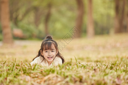 可爱的小女孩趴在草地上图片