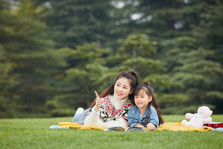 母女趴在草地上阅读图片