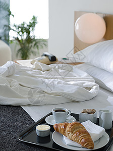 酒店床上的浴袍和早餐背景图片