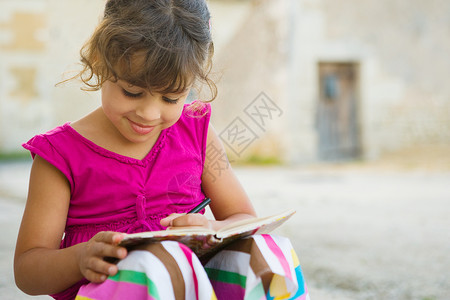 在书上写字的小女孩图片