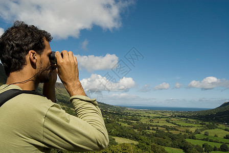 爱尔兰风景用双筒望远镜看格伦里夫的男人背景