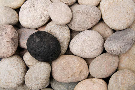 一块黑鹅卵石和其他鹅卵石背景图片