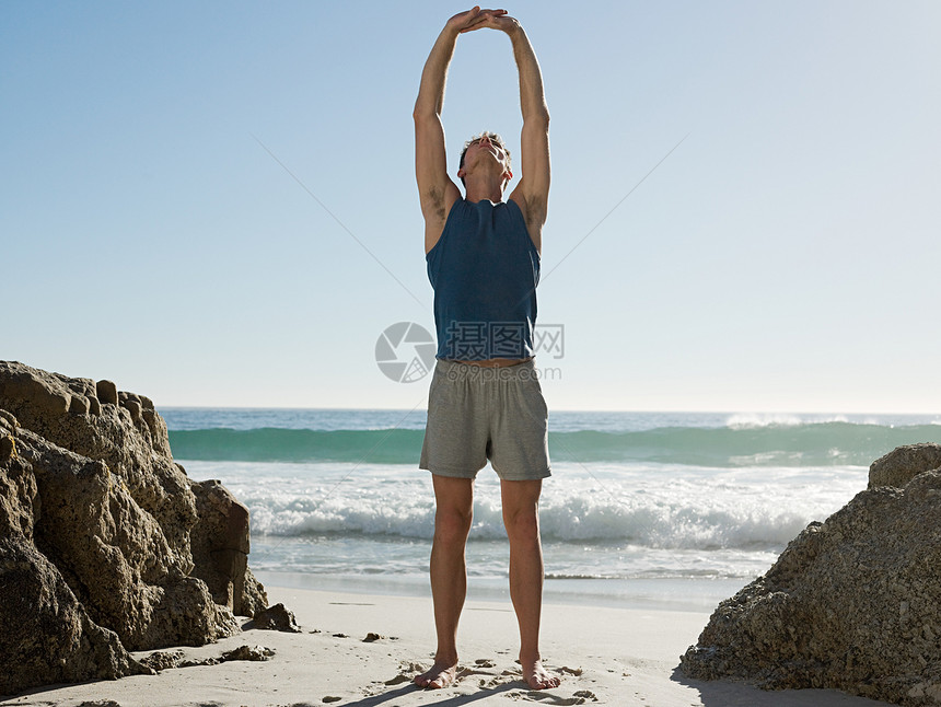 在海滩上做瑜伽的年轻人图片