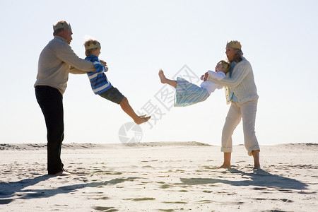 祖父母和孙子在海滩上玩耍图片