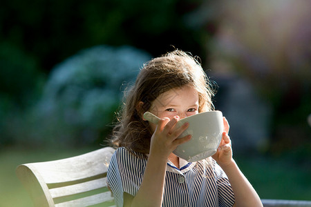 年轻女孩在花园里喝酒童年高清图片素材