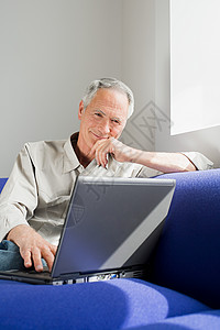 一个使用笔记本电脑的老人白天高清图片素材