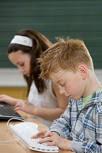 孩子们在打字电脑键盘高清图片素材