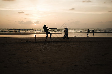 孟买海滩上打板球的人背景图片