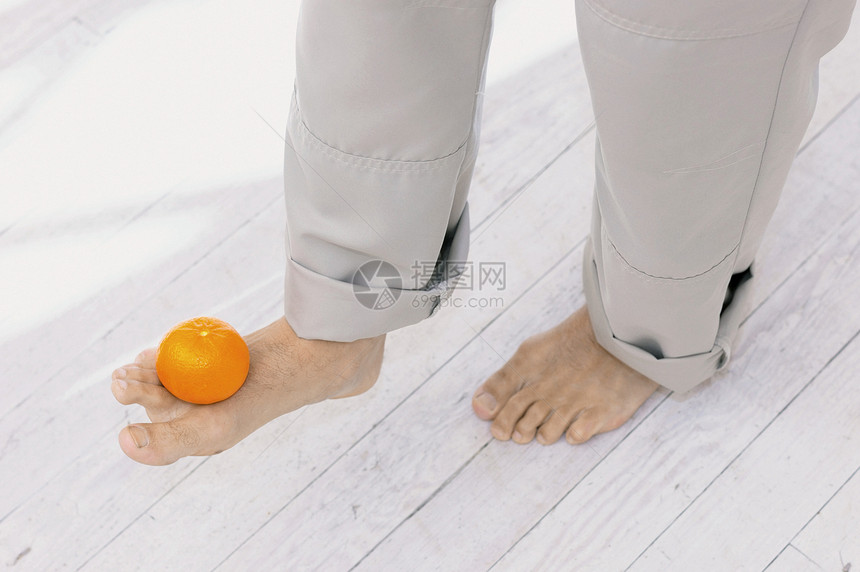 用脚垫着橘子图片