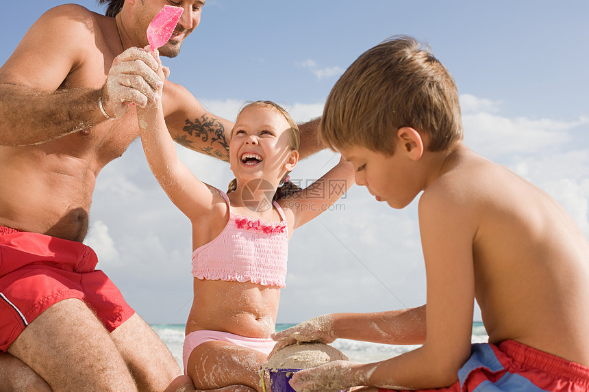 一起在沙滩上玩耍的一家人图片