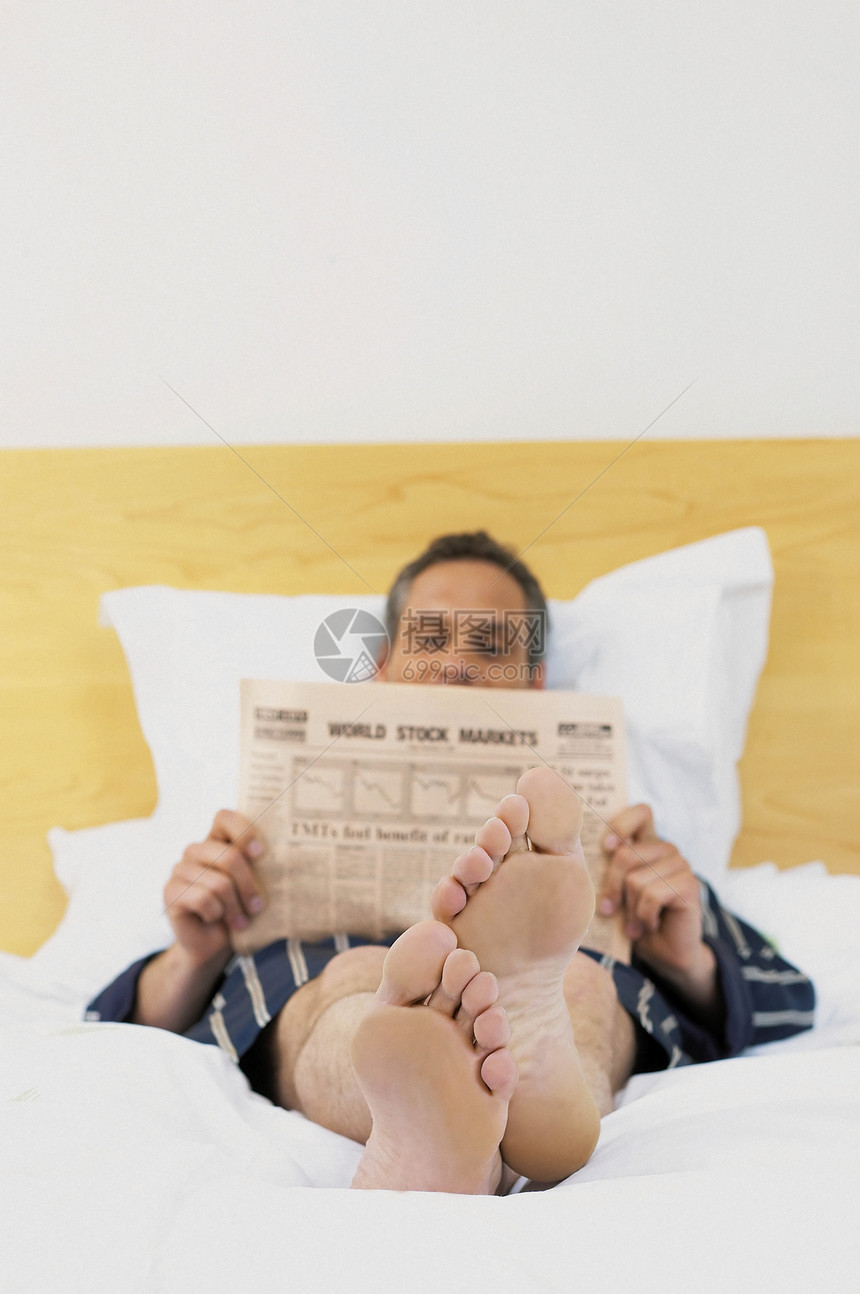 躺在床上看报纸的人图片