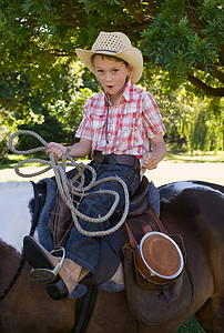 骑着马牵着套索的男孩图片