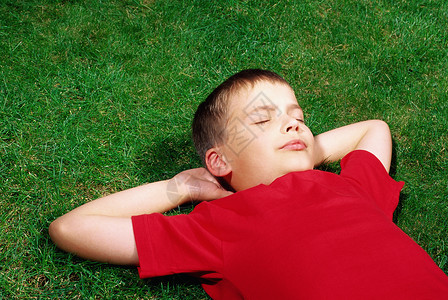 躺在草坪上的男孩图片