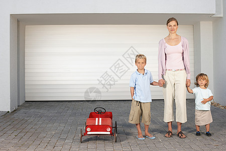 家庭车库母亲和孩子们站在车库外背景