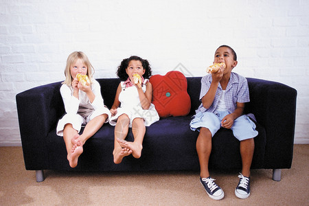 丹嫩沙多男孩和女孩在沙发上吃饭背景