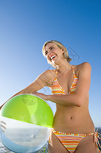 抱着沙滩球大笑的女人图片