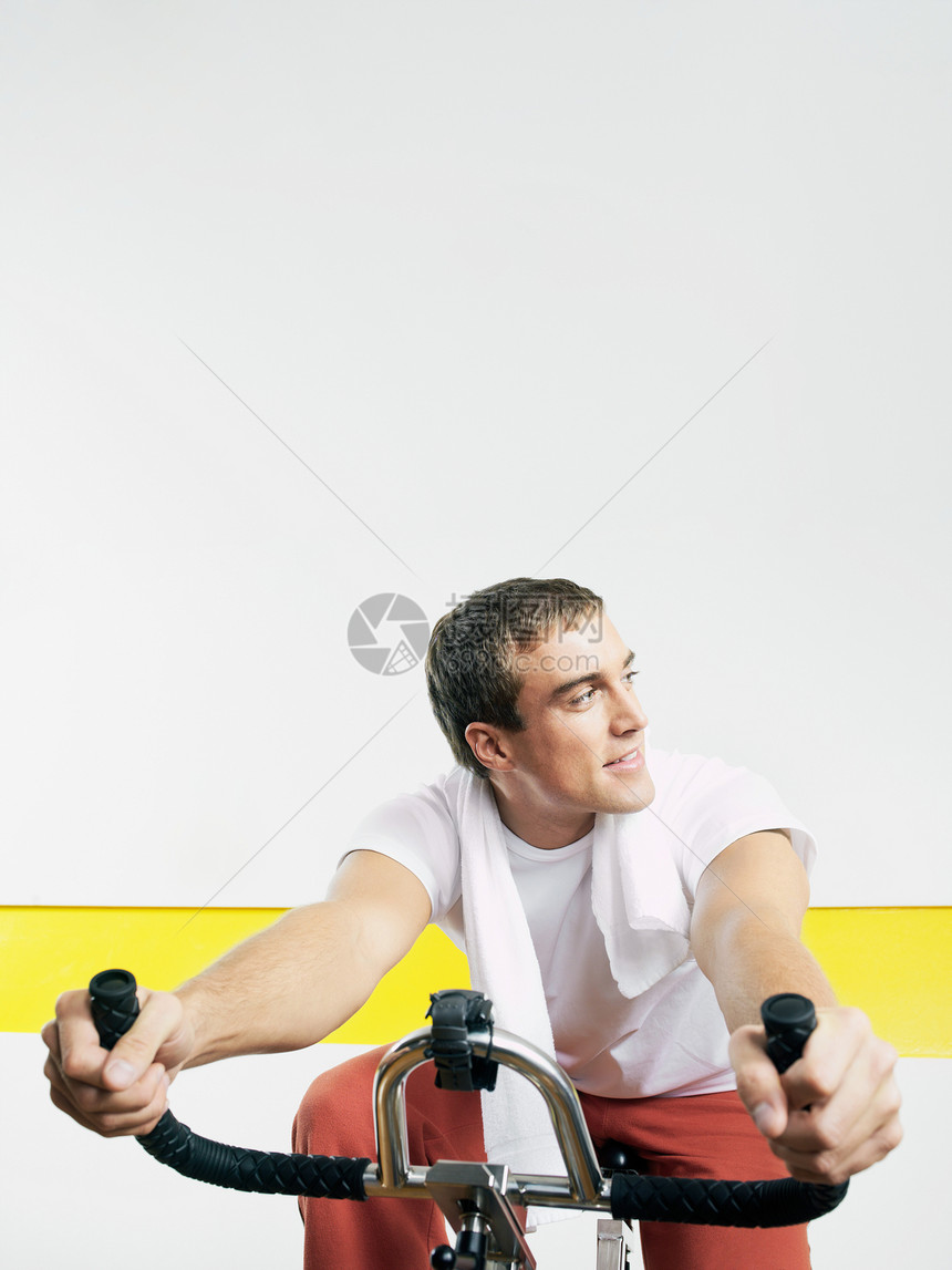 健身俱乐部骑健身自行车的人图片