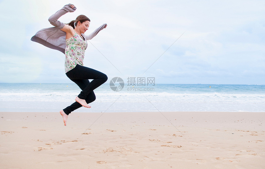 女人在海滩上跳跃图片
