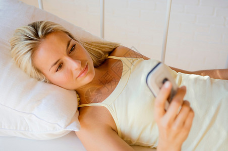 在床上用手机的女人图片