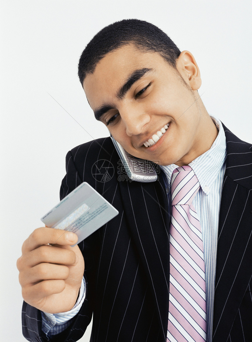 看信用卡打电话的商人图片