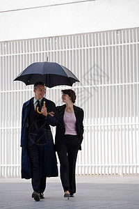 夫妇在雨伞下行走图片