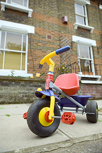 人行道上的儿童三轮车背景图片