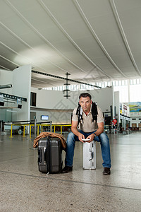 坐在机场行李上的人图片
