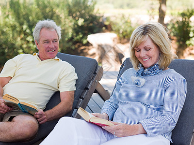 在花园休息室里看书的成年夫妇外国人像高清图片素材